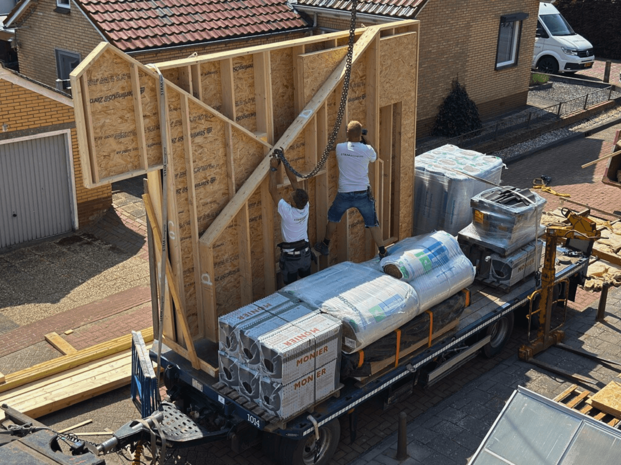 Prefab wandelement wordt met de kraan naar de dakopbouw in Zuilichem gehesen