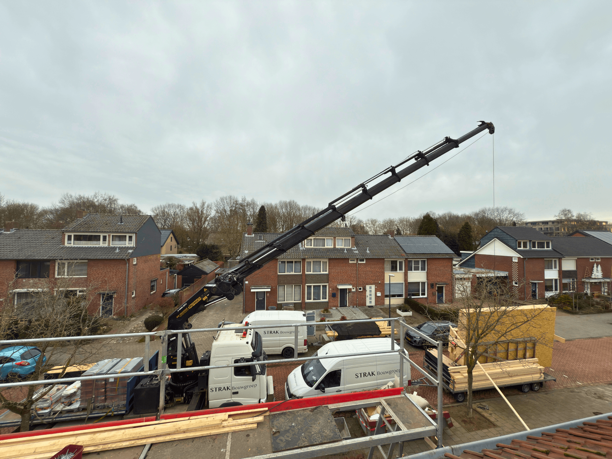 Prefab module wordt met kraan op het dak geplaatst