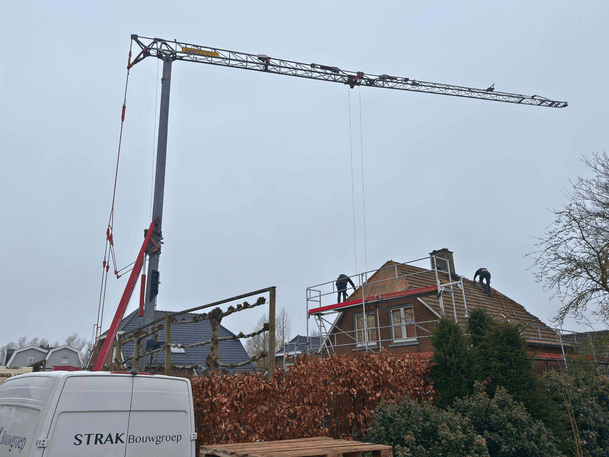 Kraan verwijdert oude dakpannen in Nederhemert