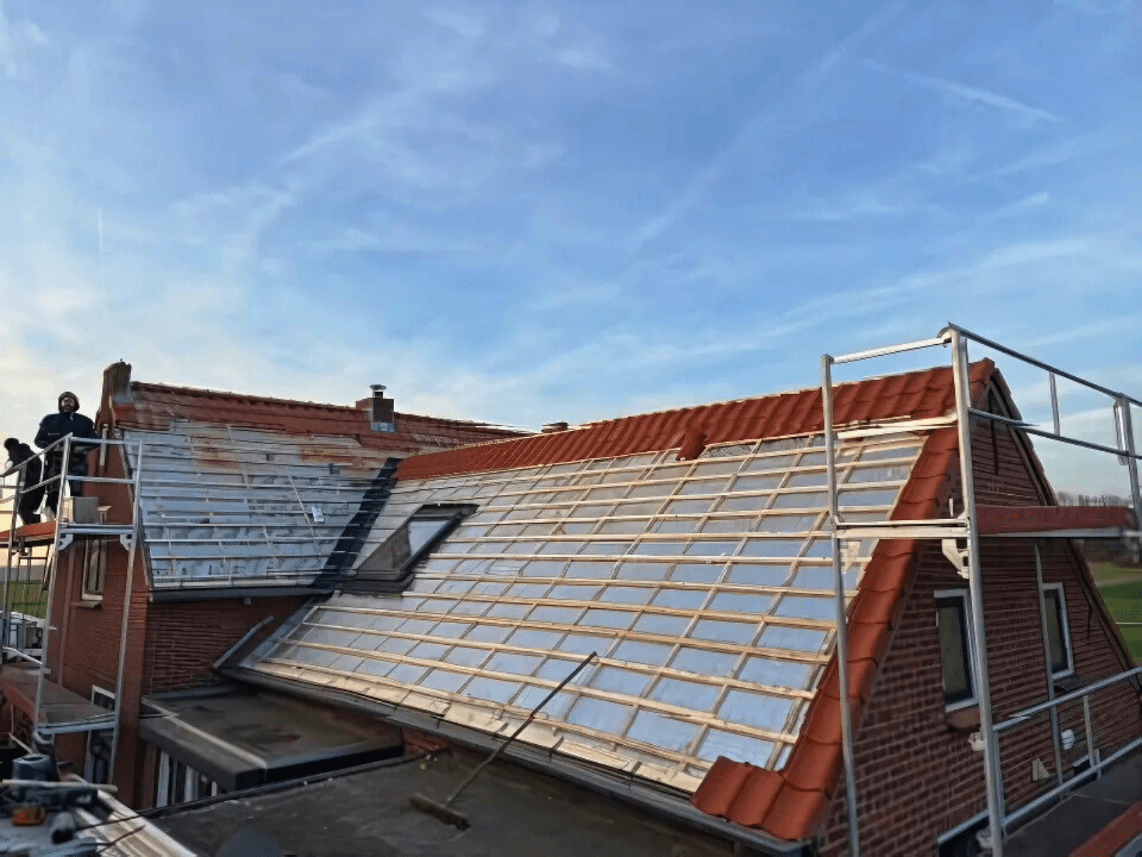 Isolatieplaten met panlatten en de eerste nieuwe dakpannen in Meeuwen