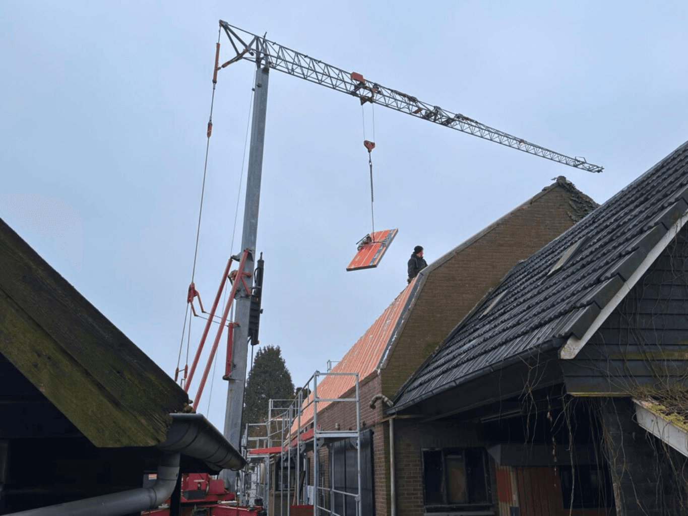 Kraan hijst een IsoBouw SlimFix isolatieplaat op het dak in Rossum
