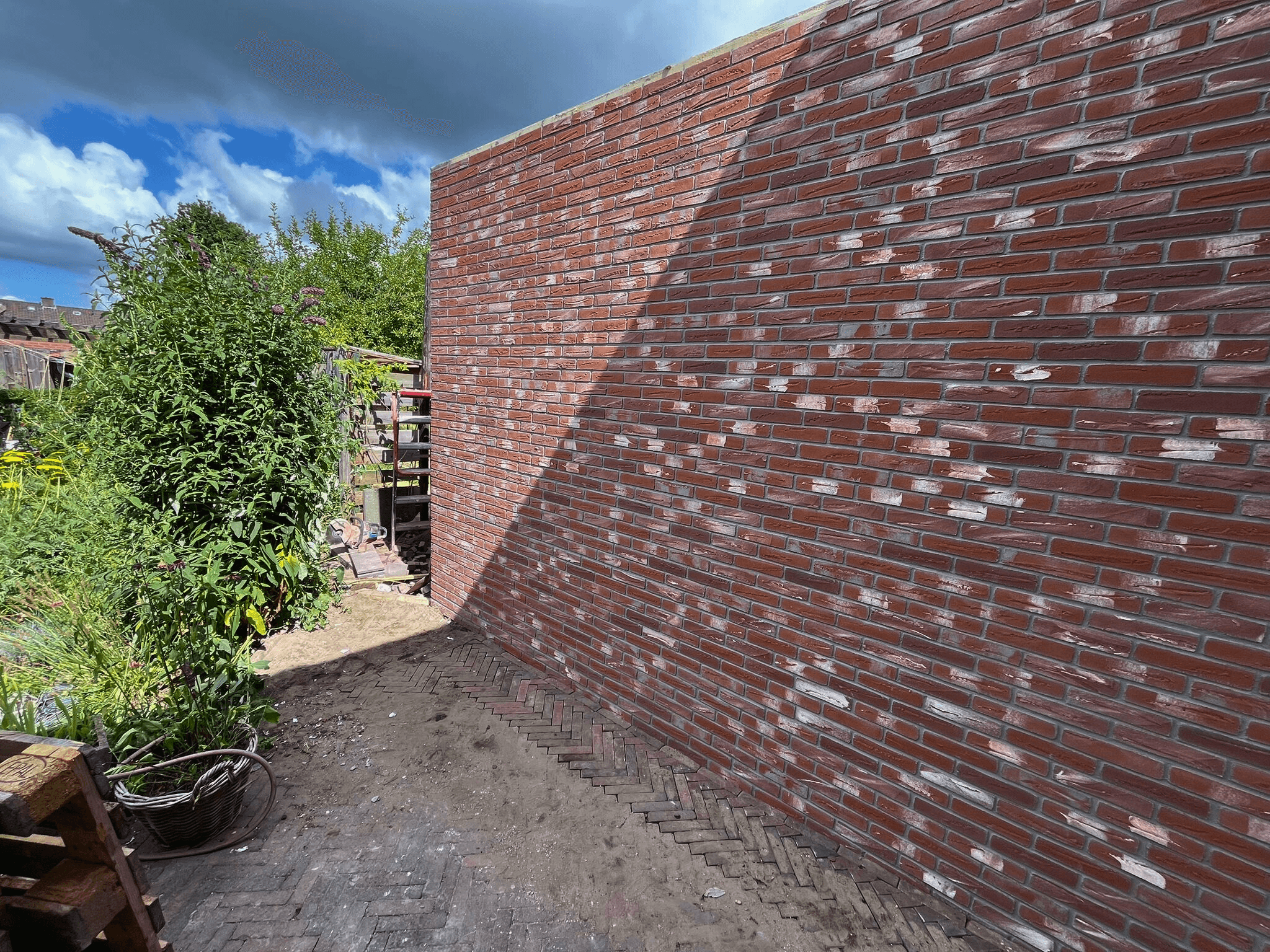 Muren met handvormstenen en grote schuifpuien met geisoleerd glas