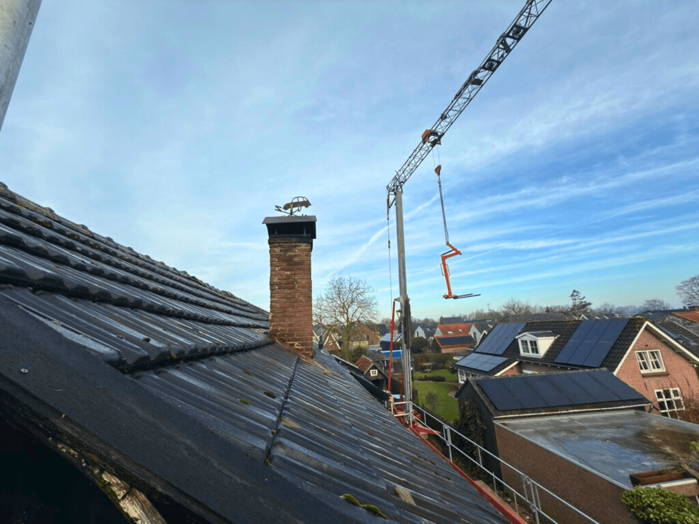 Het oude pannendak met schoorsteen vóór de dakrenovatie in Rossum