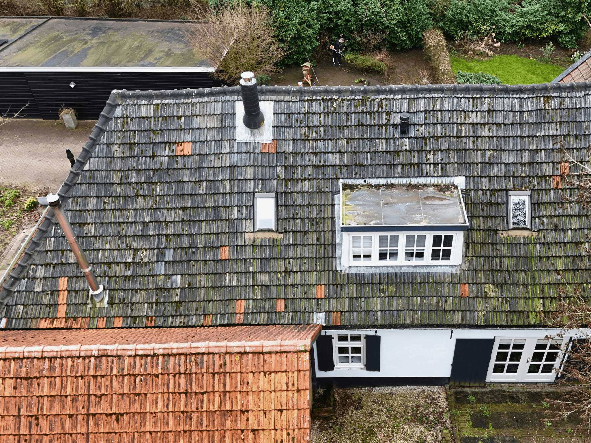 Versleten dakpannen op het dak in Rossum voor de renovatie